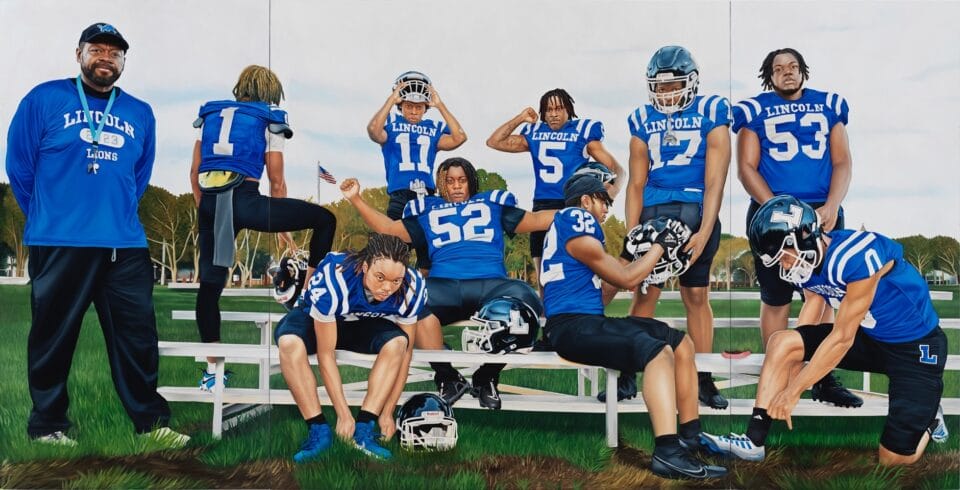 a wide, horizontal triptych of football players and a coach in blue uniforms, sitting or standing near bleachers and getting suited up, some looking directly at the viewer, including the coach, who stands with his hands behind his back