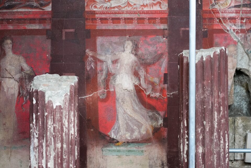 part of a large-scale fresco uncovered in Pompeii inside of a banquet hall, depicting a Dionysian scene in mostly red