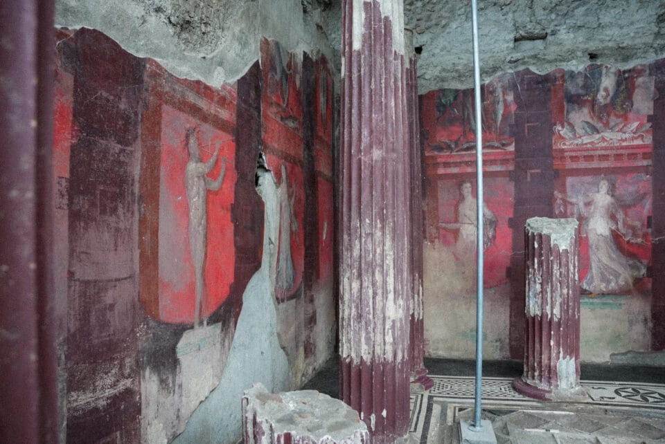 a corner of a large-scale fresco uncovered in Pompeii inside of a banquet hall, depicting a Dionysian scene