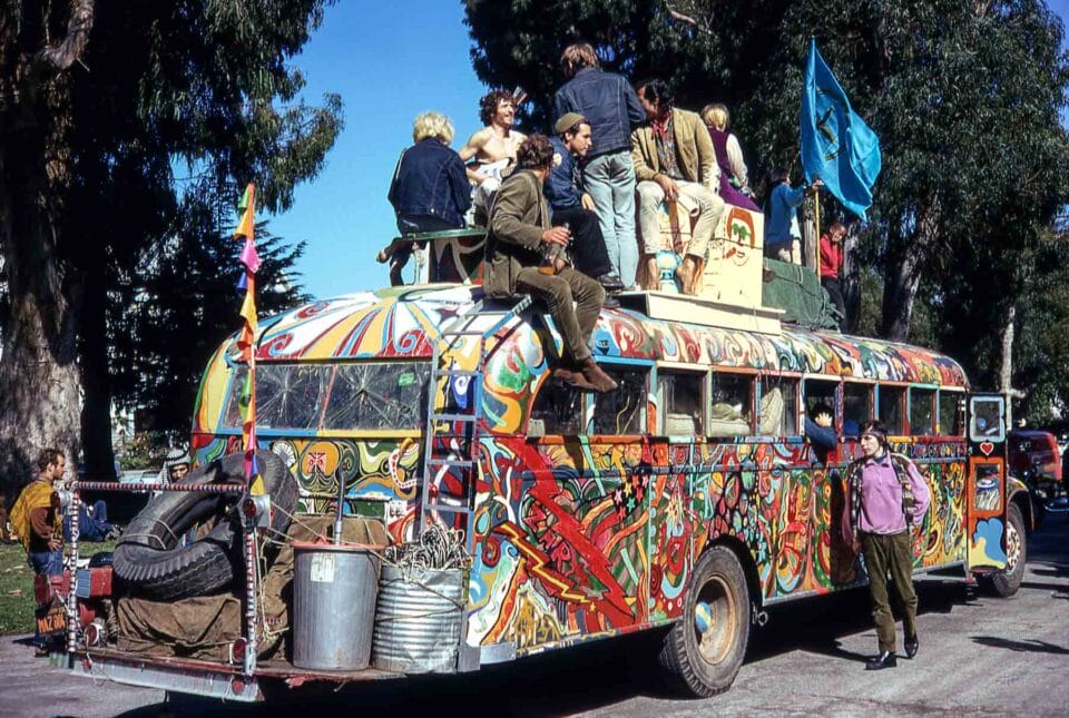 people sit atop an elaborately painted bus